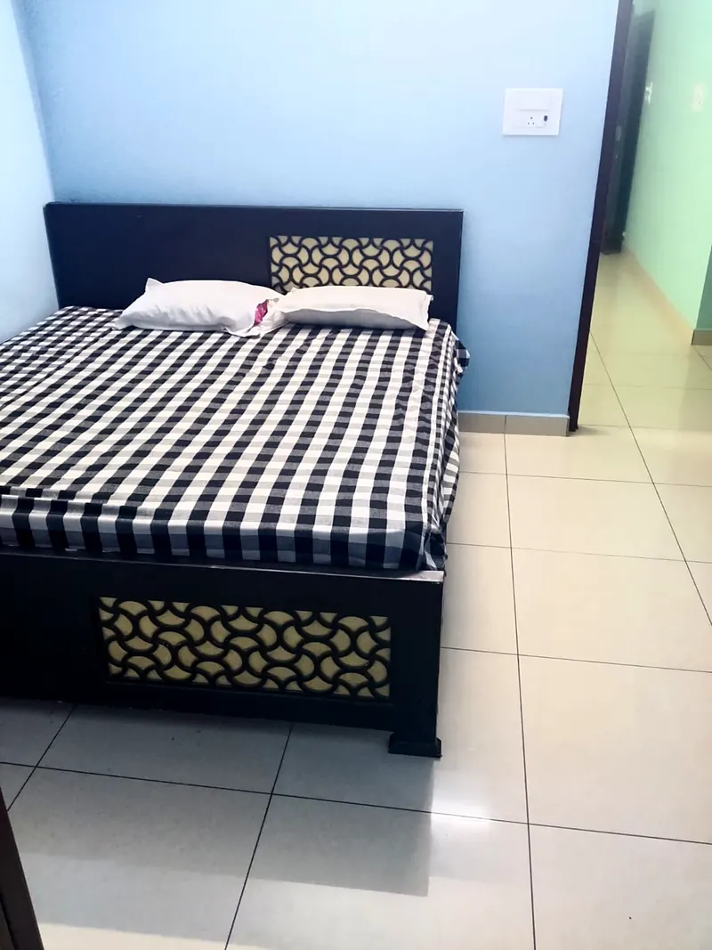 Double room with a modern bed and tiled floor at Uddish Residency