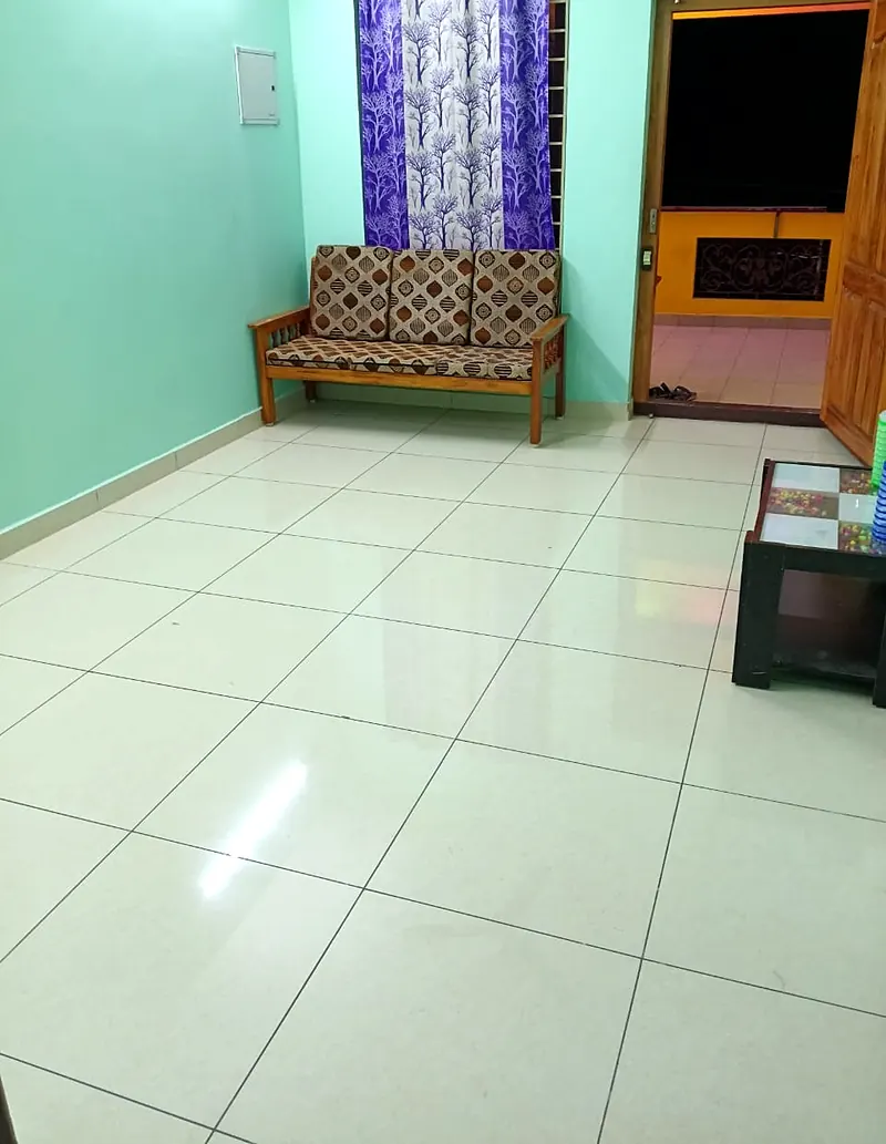 Sitting area with sofa and balcony door at Uddish Residency