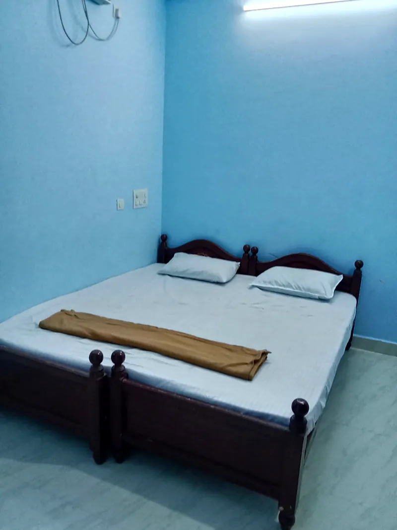 Room with two single cots placed together at Uddish Residency Pondicherry